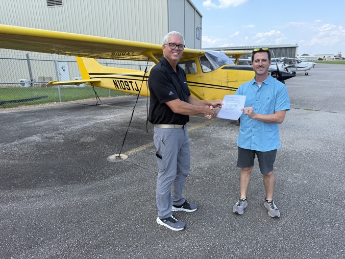 Shaking hands in front of N109TJ, holding my temporary airman certificate, on the day of my checkride.